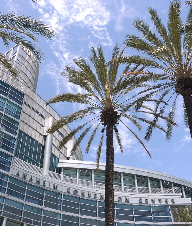 Exterior view of the Anaheim Convention Center with palm trees, site of AIMExpo 2025.